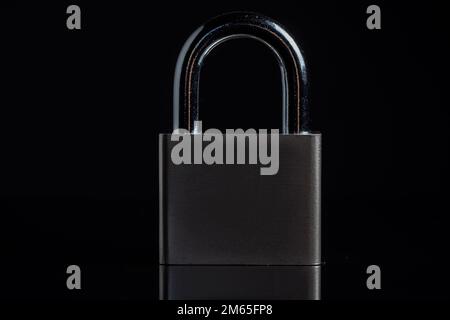 Steel padlock on the black textured background. Stock Photo