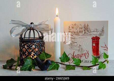 Simple Christmas Display on mantelpiece with lantern, candle card and Ivy.  Editorial use only. Stock Photo