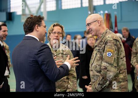 ANSBACH, Germany - Dr. Johannes Urban, ministerial counsellor, Head of Armed Forces Affairs, Security Defense Policy in the Bavarian State Chancellery, left, talks to Maj. Gen. Robert Burke, deputy commanding general of support, V Corps, right, and Col. Karen E. Hobart, commander, U.S. Army Garrison during the U.S. Army V Corps welcome ceremony at Barton Barracks in Ansbach, Germany, Tuesday, April 5. During the ceremony, the V Corps headquarters and the headquarters and headquarters battalion uncased their colors at their temporary home. The presence of the entire Victory Corps headquarters i Stock Photo