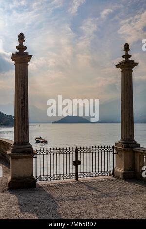 ornamental balustrade columns and gates leading to boat landing on the shore of lake como at bellagio at sunset Stock Photo