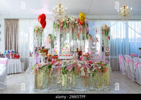 The wedding table of the bride and groom is decorated with many different flowers. A big cake on the bride's table. Ukraine, Vinnytsia, August 10, 202 Stock Photo