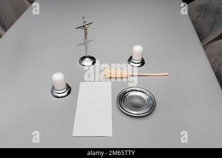 A steel caroling set lying on a gray tablecloth, traditional priest caroling in Poland, with an envelope with money. Stock Photo