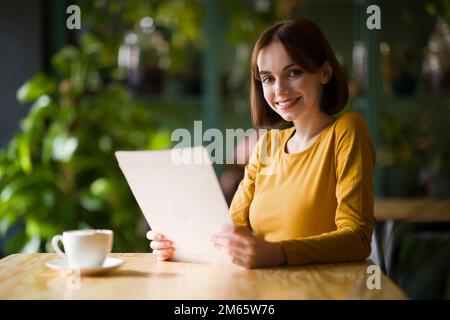 Happy beautiful young woman chilling at cafe, drinking coffee Stock Photo