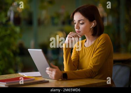 Confident young woman entrepreneur working online at cafe Stock Photo
