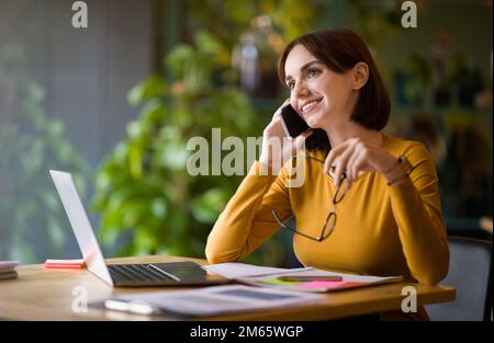 Attractive young businesswoman working at coffee shop Stock Photo