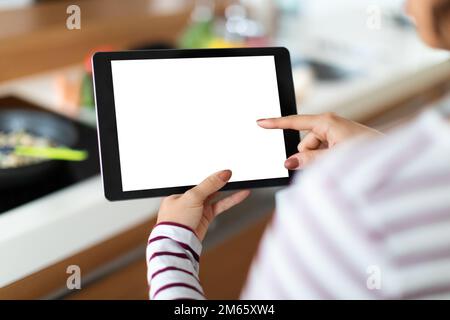 Cropped of woman cooking at home, using digital tablet, mockup Stock Photo