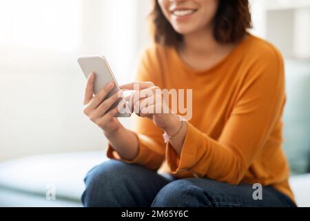 Online Shopping. Smiling Young Female Using Modern Smartphone At Home Stock Photo