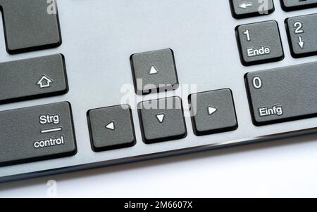 Simple modern office desktop PC, computer keyboard arrow keys, object detail, closeup. Arrows, different directions, directional keys, many routes, di Stock Photo
