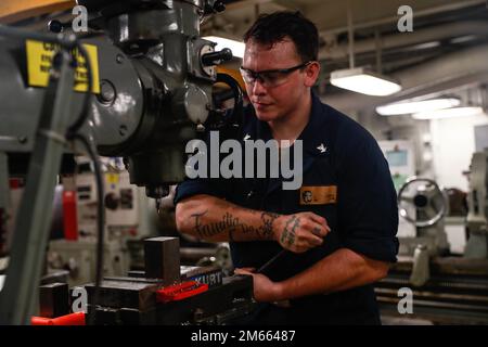 PHILPPINE SEA (April 5, 2022) Machinery Repairman 3rd Class Joseph Cunha, from Glenn Ellyn, Ill., drills a carbon steel block aboard the Nimitz-class aircraft carrier USS Abraham Lincoln (CVN 72). Abraham Lincoln Strike Group is on a scheduled deployment in the U.S. 7th Fleet area of operations to enhance interoperability through alliances and partnerships while serving as a ready-response force in support of a free and open Indo-Pacific region. Stock Photo