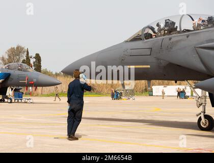 A U.S. Air Force crew chief salutes anm F-15E Strike Eagle pilot at Andravida Air Base, Greece, April 6, 2022. The 492nd Fighter Squadron assigned to the 48th Fighter Wing participated in INIOCHOS 22, a Hellenic air force-led exercise designed to enhance the interoperability and skills of allied and partner forces in the accomplishment of joint operations and air defenses. Stock Photo