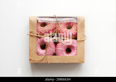 Pink donuts packed in box isolated on white background, natural light Stock Photo