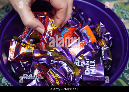 Picking out Heroes chocolate from tin Stock Photo