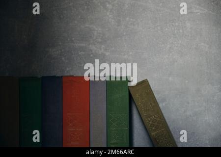 Home library of old battered retro books with colored spines Stock Photo