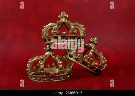 Happy Three King's Day. Three gold crowns on red background. Concept for Reyes Magos, Three Wise Men or Happy Epiphany day. Stock Photo