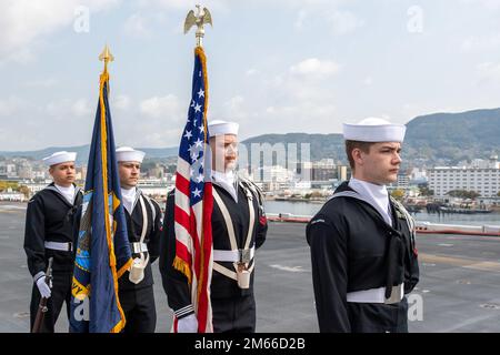 SASEBO, Japan (April 7, 2022) Sailors assigned to the forward-deployed amphibious assault ship USS America (LHA 6) parade the colors during a change-of-command ceremony on the ship’s flight deck. America, lead ship of the America Amphibious Ready Group, is operating in the U.S. 7th Fleet area of responsibility to enhance interoperability with allies and partners, and serve as a ready response force to defend peace and stability in the Indo-Pacific region. Stock Photo