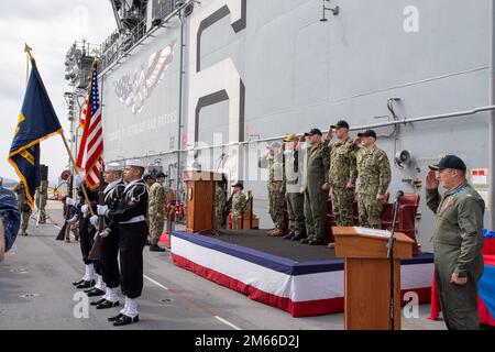 SASEBO, Japan (April 7, 2022) Sailors assigned to the forward-deployed amphibious assault ship USS America (LHA 6) present the colors during the National Anthem at a change-of-command ceremony on the ship’s flight deck. America, lead ship of the America Amphibious Ready Group, is operating in the U.S. 7th Fleet area of responsibility to enhance interoperability with allies and partners, and serve as a ready response force to defend peace and stability in the Indo-Pacific region. Stock Photo