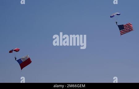 The American flag and Chilean Flag are flown from the feet of an Air Force Academy Wings of Blue Parachute Demonstration Team member and Boinas Azules (Blue Berets) Parachute Demonstration Team member, respectively, during Feria Internacional del Aire y del Espacio (FIDAE), Latin America’s largest aerospace, defense and security exhibition, in Santiago, Chile, April 7, 2022. The demonstration showcasing both countries’ flags symbolize the important partnership and respect between the two countries. Stock Photo