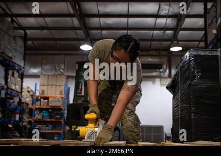 U.S. Air Force Airman 1st Class Ejlyn Smith, network systems operator, 386th Expeditionary Communications Squadron, uses an electric sander on wood for a project at the U-Fix-It warehouse at Ali Al Salem Air Base, Kuwait, April 7, 2022. The 386th Expeditionary Civil Engineer Squadron’s self-help store, known here as U-Fix-It, provides material and supply options for anyone in need of supplies that range from power production and electrical to heating, ventilation and air conditioning, and more. The shop provides customers and facility managers the tools to carry out mission-enhancing projects Stock Photo