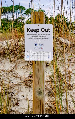 A sign warns people not to walk on sand dunes due to a sand dune restoration project, Jan. 1, 2023, in Dauphin Island, Alabama. Stock Photo