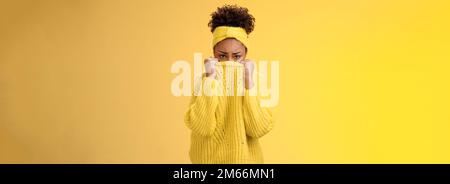 Cute upset scared timid insecure african-american offended girl hiding face pulling sweater collar nose frowning pouting look sorrow insulted afraid Stock Photo