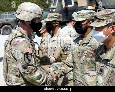 Maj. Gen. David Lesperance (left), the commanding general of the 2nd Infantry Division/ROK-US Combined Division, presents a coin on April 8, 2022 to Sgt. Sedrick Hill, a multi-launch rocket system crew member with the 1st Battalion, 38th Field Artillery Regiment, 210th Field Artillery Brigade with a coin to recognize his efforts during recent training. Stock Photo