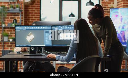 Diverse engineers colleagues brainstorming ideas to develop clamp product, doing teamwork to create mechanical prototype with cad software. Young technicians working in manufacturing industry. Stock Photo