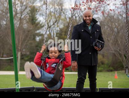 Cleveland Brown V watches his son, Cleveland Brown VI, 4, swing at Silver Lake Park in Dover, Delaware, April 9, 2022. Brown served in the United States Air Force for six years and has been a military spouse for nine. Stock Photo