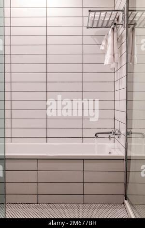 Detail of a bathroom with white tiles covered walls in a hotel Stock Photo
