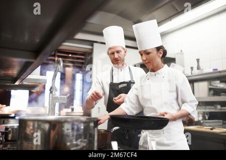 Passing on her culinary knowledge. the inner working of a professional kitchen. Stock Photo