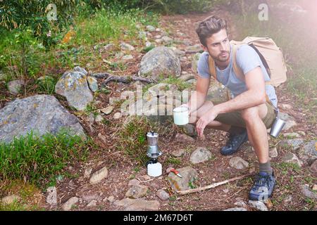 Adventure begins after coffee. a handsome hiker having coffee. Stock Photo