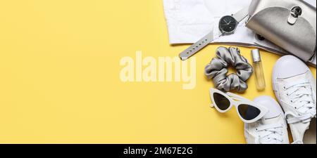 Stylish female clothes, silk scrunchy and different accessories on yellow background with space for text Stock Photo