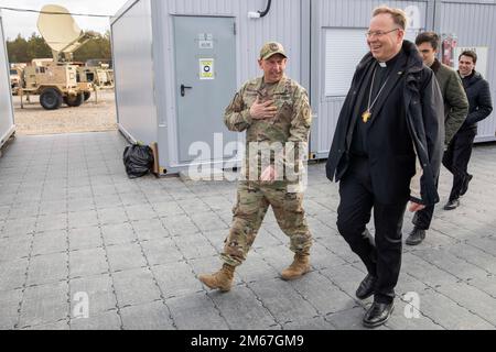 U.S. Army Lt. Col. Paul Godson, commander of 3rd Battalion, 66th Armored Regiment, 1st Infantry Division, gives Lithuanian Archbishop Gintaras Grušas a tour of Camp Herkus, Lithuania, April 12, 2022. Stock Photo