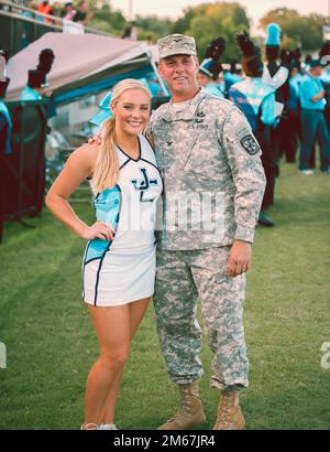 Savannah Taylor, then a senior at James Clemens High School in Madison, shares a sideline moment with her father, Courtney Taylor, who retired as a colonel. Stock Photo