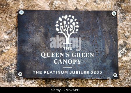 A plaque commemorating the Queen’s Green Canopy event rests on a stone at RAF Croughton, England, April 13, 2022. The event celebrated the Queen’s Platinum Jubilee initiative, marking the 70th year of her reign. During the event, trees were planted to create a legacy in honor of the queen’s leadership of the nation. 501st Combat Support Wing,England,Queens Platinum Jubilee,RAF Croughton,U.S. Air Force,USAFE, Stock Photo