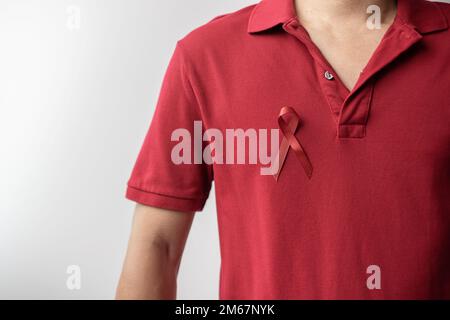 Burgundy Red Ribbon for March multiple myeloma Cancer and December World Aids Day Awareness month. Healthcare and world cancer day concept Stock Photo