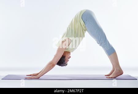 Stretching her back. Full length shot of an attractive woman stretching before yoga. Stock Photo