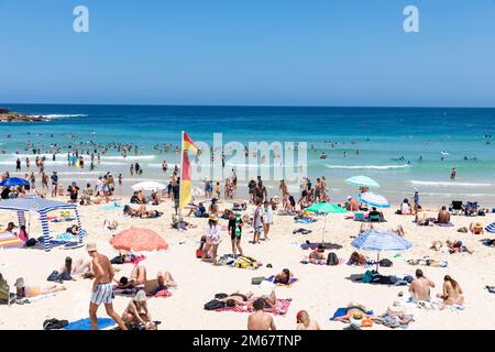 Bondi Beach in Sydney, summers day 2023, crowded beach and people in the ocean, blue sky, Sydney eastern suburbs, NSW,Australia Stock Photo