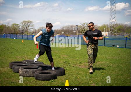 220414-N-WF272-1185 CAMDEN, N.J. (April 14, 2022) U.S. Marine Corps Staff Sgt. Ruben Cabrera, right, a native of Clifton, N.J., assigned to Marine Corps Recruiting Station South Jersey, serves as an obstacle course observer for a Mastery High School of Camden student during a Military Field Day held in Camden, New Jersey. As part of the field day, students and local service members played a variety of sports, participated in outdoors activities and discussed opportunities offered by the armed forces. Stock Photo