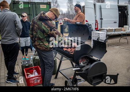 U.S. Army Chief Warrant Officer 2 Dwayne Hawkins, Apache helicopter pilot, Alpha Company, 1-3rd Attack Battalion, 12th Combat Aviation Brigade, conducts grilling operations in support of the battalion organizational day Lielvarde Air Base, Latvia, April 14, 2022. 12 CAB is among other units assigned to V Corps, America's Forward Deployed Corps in Europe that works alongside NATO Allies and regional security partners to provide combat-ready forces, execute joint and multinational training exercises, and retains command and control for all rotational and assigned units in the European Theater. Stock Photo