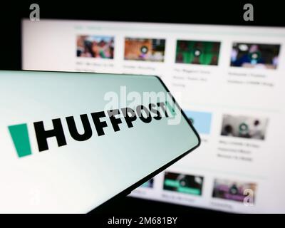 Mobile phone with logo of American news company HuffPost on screen in front of business website. Focus on center-right of phone display. Stock Photo