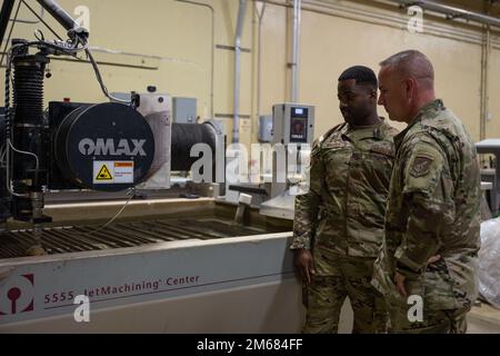 U.S. Air Force Chief Master Sgt. David R. Wolfe, Pacific Air Forces command chief, is briefed by an Airman with the 36th Maintenance Group on a water jet cutter at Andersen Air Force Base, Guam, April 14, 2022. The purpose of Wolfe’s visit was to speak with Airmen in a variety of career fields about Andersen AFB, it’s importance in the region and how the Air Force could contribute to further enhancing the capabilities displayed across the base. Stock Photo