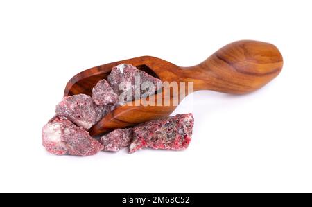 Benzoin Siam resinoid in wooden spoon, isolated on white background. Mix of benzoin and Dammar resin. Tropical resins. Top view Stock Photo
