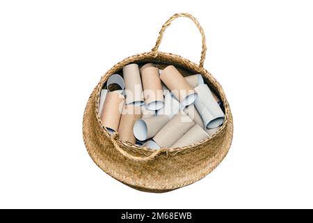 A lot of empty rolls of toilet paper lies in a basket, isolated on a white background. Concept of paper recycling and reuse Stock Photo