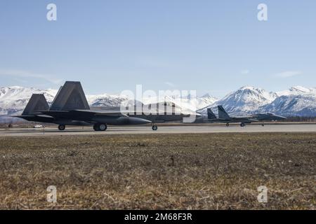 Two F-15C Eagles from the 144th Fighter Wing and two F-22 Raptors from the 3rd Fighter Wing prepare to take off from Joint Base Elmendorf-Richardson, Alaska, April 18, 2022, during an Aerospae Control Alert training scramble. It has been almost a decade since F-15 Eagles have sat alert in the region, protecting the airspace of the United States and Canada. The overall alert mission and corresponding training missions at JBER focused on fighter integration between fourth-generation F-15 Eagles and fifth-generation F-22 Raptors and their ability to interoperate seamlessly. Stock Photo