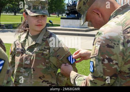 Pvt. Niah Allen, an allied trade specialist from Lugoff, South Carolina, assigned to the 3rd Infantry Division Artillery, receives a 3rd ID unit patch during a patching ceremony at Cashe Garden on Fort Stewart, Georgia, April 19, 2022. During the ceremony, Soldiers received the Division patch, which represents the history of the Marne Division: the three white stripes are symbolic of the three major operations in which the division participated during World War I, the Battle of the Marne River, the Meuse-Argonne Offensive and the St. Mihiel Offensive, and the blue symbolizes the loyalty of tho