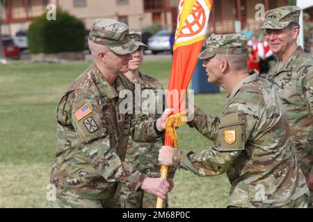 Maj. Gen. Christopher L. Eubank (right), NETCOM Commanding General passes the Command colors to NETCOM Command Sergeant Major Jason McCoy (left) during the unit's Change of Command, April 19, 2022, at Brown Parade Field, Fort Huachuca, Ariz. Stock Photo