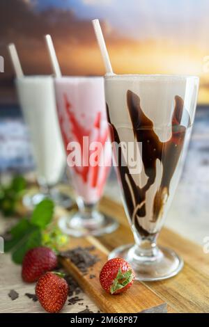 3 shakes chocolate ,strawberry and vanilla with a sunset Stock Photo