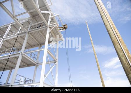 A Green Beret with 10th Special Forces Group (Airborne) prepares to rappel from a tower at Fort Carson, Colorado, April 19, 2022. Special Forces Operators use rappelling to insert into areas from elevated positions when time or surprise is required by the mission. Stock Photo