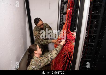 Airman 1st Class Sofaira Williams, 608th Air Communication Squadron network systems technician (top), and Airman 1st Class Victoria Montville, 608th ACOMS client systems technician (bottom), trace out connections in the ACOMS patch closet. The closet is used for troubleshooting network connectivity for users’ SIPR access. 8th Air Force,AFGSC,Barksdale Air Force Base,Joint-Global Strike Operations Center, Stock Photo