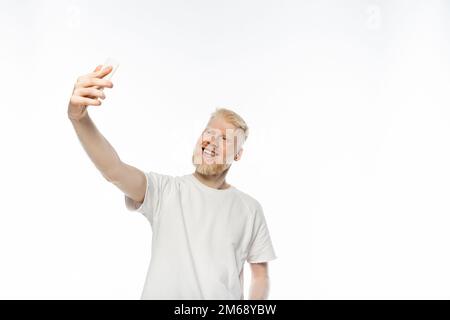 happy albino man in t-shirt taking selfie on smartphone on white background,stock image Stock Photo
